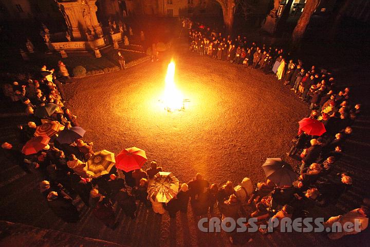 2012.04.07_20.56.30.jpg - Zuerst versammelt sich die Gemeinde im Stiftshof, wo vom Abt das Feuer gesegnet wird. Daraufhin wird die Osterkerze angezündet und von ihr aus wird das Feuer an die Gläubigen weitergereicht.