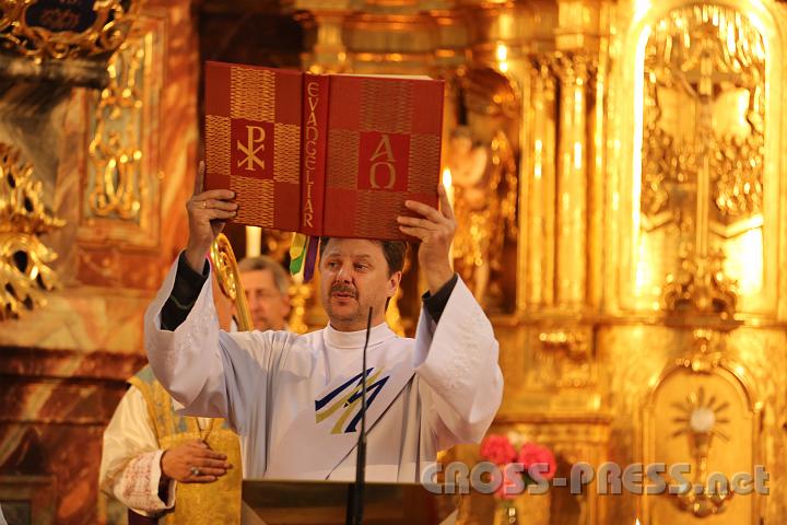 2012.07.21_11.44.44.jpg - Diakon Christian Ganneshofer hebt das Evangeliar hoch vor dem goldenen Altar der Wallfahrtskirche Pöllauberg.