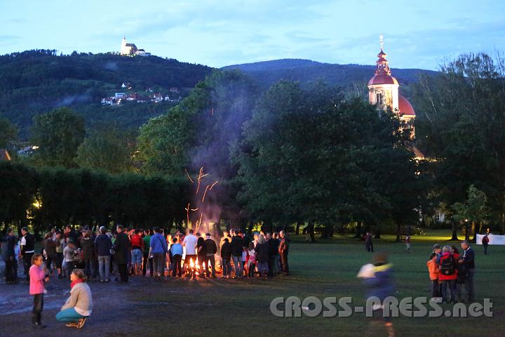 2012.07.21_21.32.58_01.jpg - Gute Stimmung unter den mehr als 180 Familien beim Lagerfeuer im Schlosspark. Im Hintergrund die Pfarrkirche Pöllau und die Wallfahrtskirche am Pöllauberg.